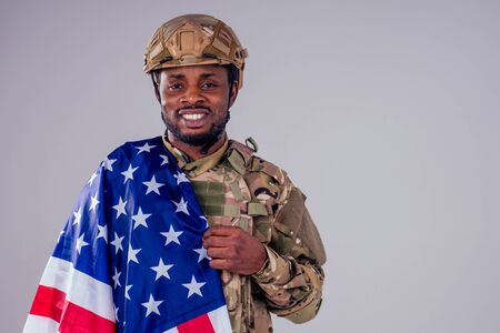African american soldier with folded arms standing in white studio