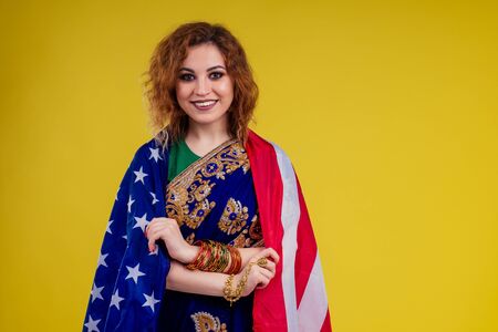 indian woman with american flag studio yellow background