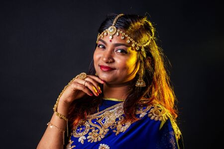 indian beautiful fashion brunette woman in blue traditional wedding rich sari with make-up on black...