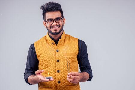 handsome indian male tradition dress prayers candle happy diwali light studio white backgroundの写真素材