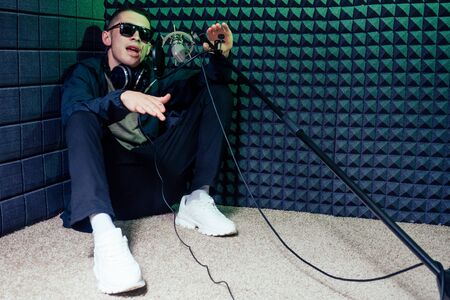 rap singer in studio voice sound recording new hit sitting on the floor.creative crisis concept .