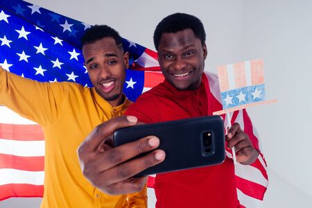 Young men with American flag on white background. happy friends ready for vacation american visaの写真素材