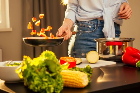 happy redhaired ginger woman cooking in evening sun lights sunset background.の写真素材