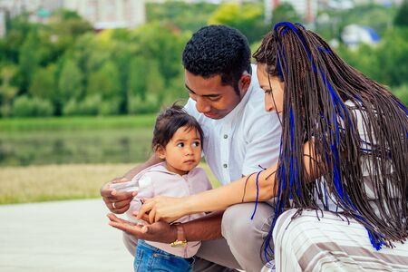 happy family applying hand-sanitizer anti-bacterial gel to daughter hands