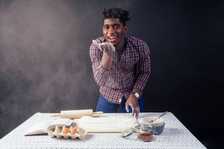 handsome and young afro african man preparing homemade cakes American Pie from fresh dough hands...