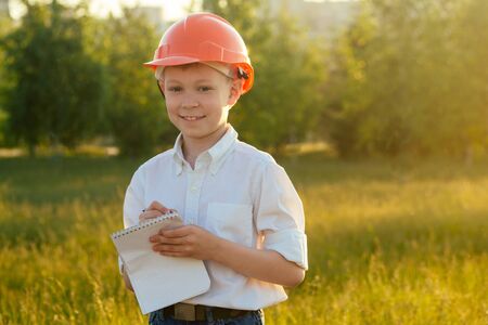 portrait of a little boy builder young in a helmet hardhat in a park . dream ideaの写真素材