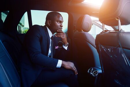 Handsome successful rich african american businessmen in a stylish black business suit and tie...
