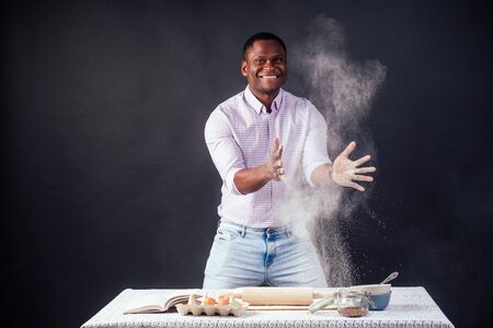 handsome and young afro african man preparing homemade cakes American Pie from fresh dough hands...