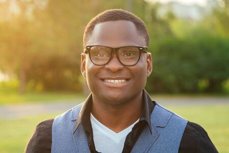 portrait of young and handsome stylish model afro- american man in a stylish blue suit wrist watch...