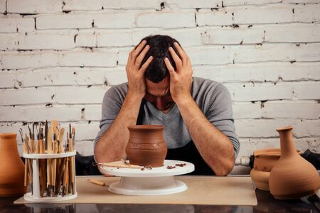 potter professional happy man working with brown clay in workshop . businessman artist trade handmade pot shopの写真素材