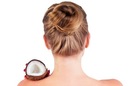 Beautiful young blonde hairstyle girl with coconut in her hand shoulders naked bare back in the studio on a white background. Beauty hair.の写真素材