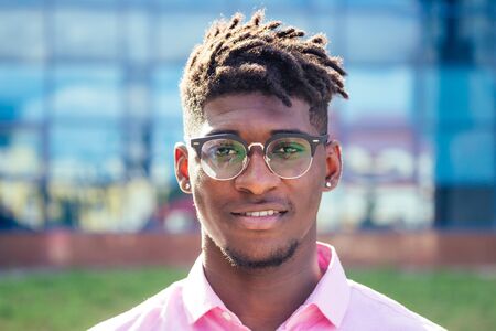portrait stylish and handsome African student American man with cool dreadlocks and earringin the...