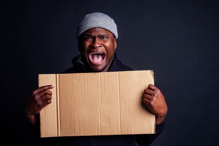 worried african american face man wearing gray hat and black hoody with hood ,shouting loud and...