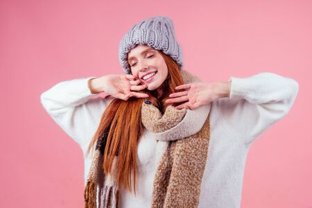 redhaired ginger woman yawning and stretching the body after winter sleeping in studio pink...