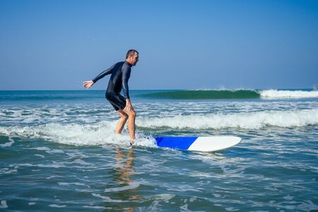 surf instructor showing how riding on big waves in Goa India.