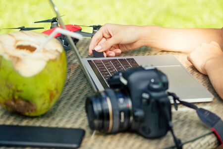 Young photographer woman feeling happy becouse she get money online while sitting at tropical cafe.の写真素材