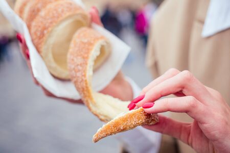 woman with an appetite eats a traditional Czech sweet Trdelnik in Prague street.の写真素材