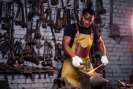 hammer industry small business concept.african american man dressed in historical clothing is...