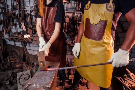 couple in love redhaired ginger young european woman and afro-american man wearing leather apron...