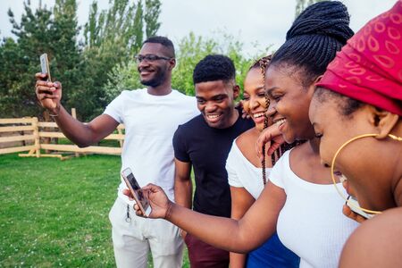 group of five friends female and male taking selfie on camera smartphone and having fun outdoors lifestyle near lakeの写真素材