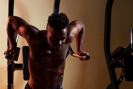 Male athletewith dreadlocks working out in the gym