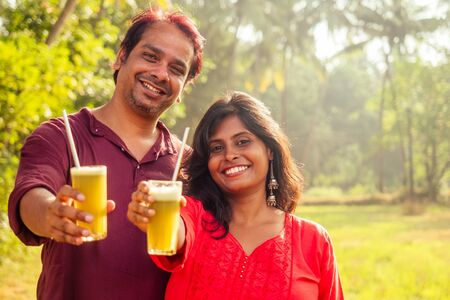 happy indian family holding glass of fresh cane juice with eco metal tube. Love to health and save planet . recyclable conceptの写真素材