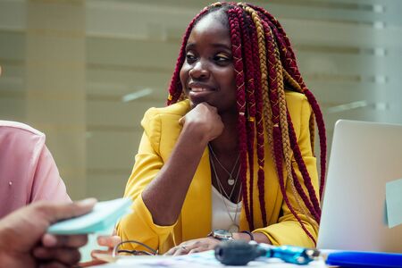 happy, afro american woman in a stylish yellow jacket and multi-colored dreadlocks pigtails...