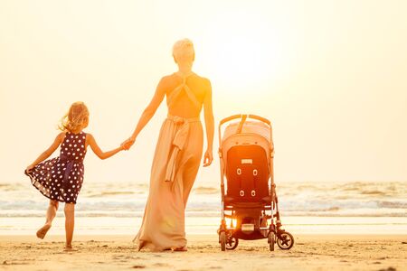 happy woman with two cute daughters outdoor walking .の写真素材
