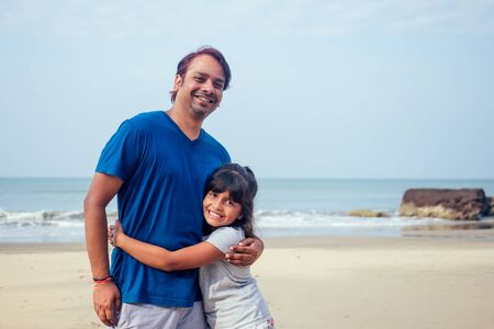 happy daughter and father having fun together in Goa .travel medical insurance concept