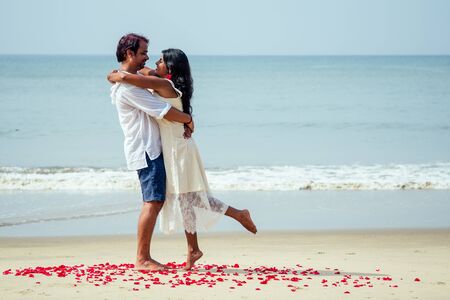 indian male making proposal with engagement ring and roses to his girlfriend at sea beach.Valentine day at Goaの写真素材