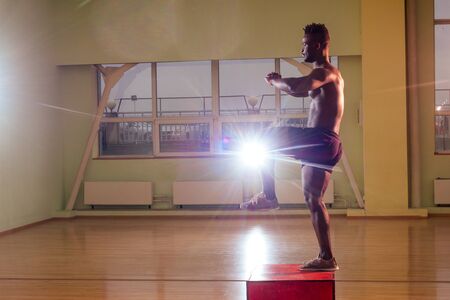 afro man doing exercise with a fit box in a gymの写真素材