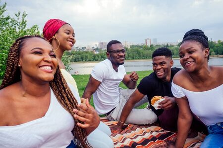 happy casual america african people having fun and eating burger outdoors lifestyle,students for a...