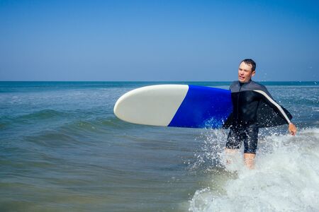 surf instructor showing how riding on big waves in Goa Indiaの写真素材