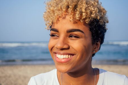 latin hispanic woman with perfect skin and curly afro hair enjoying at the beach