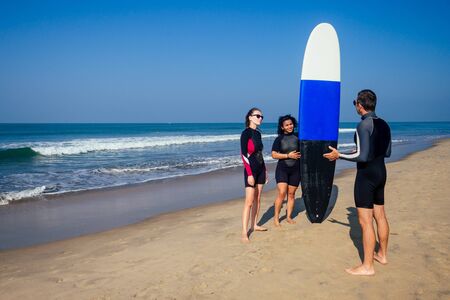 surf instructor and two girls beginner surfers on lesson in Goa India.の写真素材