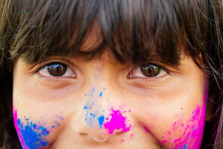 little indian girl painted her face with pink and blue colors