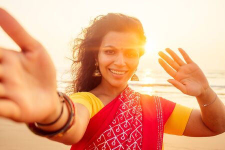 self portrait of gorgeous beautiful indian woman taking selfie photo with mobile phone camera in...