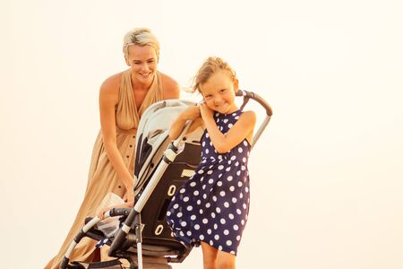 happy woman with two cute daughters outdoor walkingの写真素材