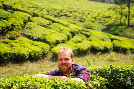 redhaired ginger male enjoying morning in India chai plantations Munnar