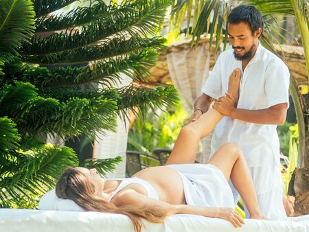 happy pregnancy wife and asian husband doing couple meditation in green park by sea beachの写真素材