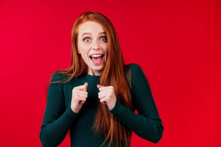 happy redhair ginger woman in studio background feeling heart thanks