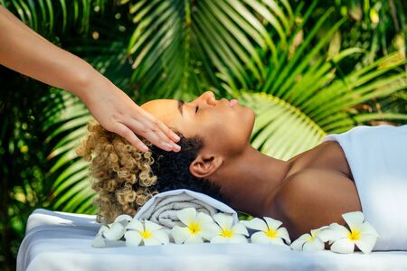 attractive african american female get treatment massage in tropics resort outdoor salon .の写真素材