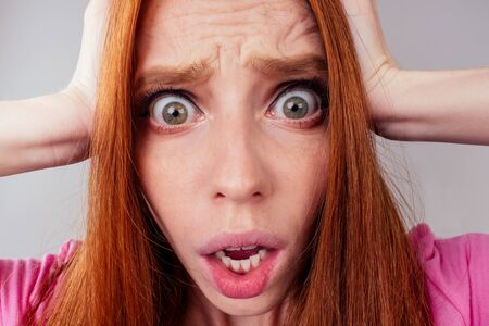 redhair ginger woman look sad because her hairs is falling ,studio gray backgroundの写真素材