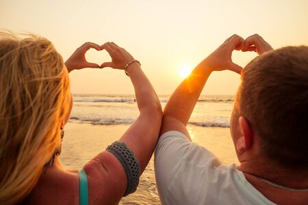 Vacation couple walking on beach together in love at sunset goa.の写真素材