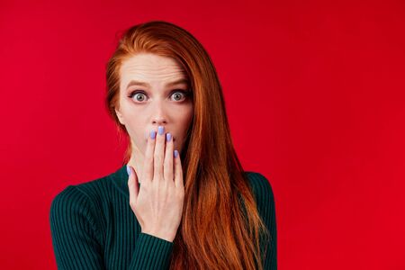 amazed redhair ginger woman worried, fear expression in studio backgroundの写真素材