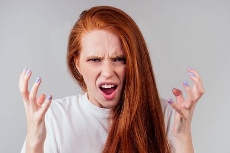 annoying redhaired ginger woman feeling irritation and anger studio backgroundの写真素材