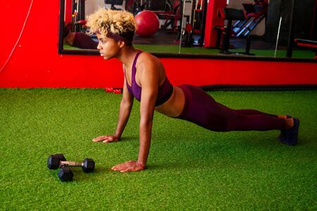 happy smile african american woman workout weights arms muscle loss in gymの写真素材