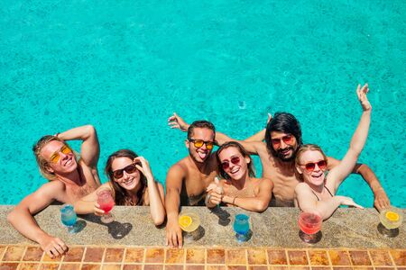 chers drinking cold lemonade in swimmingpool conceptの写真素材