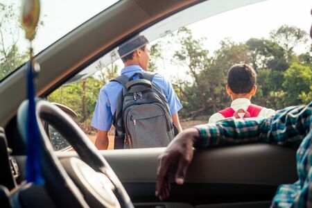 indian family driving boys to school In front of house gatesの写真素材