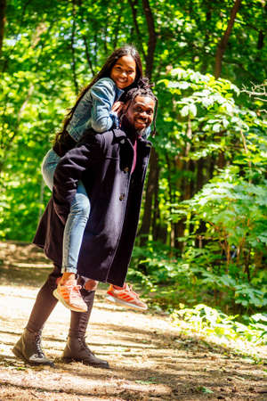 african american man with mixed race asian woman walking in the park